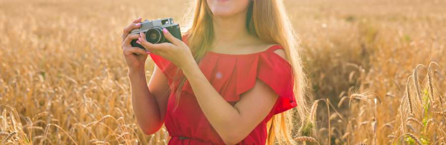 Bild, Kamera, Fotokamera, analog, Mädchen, Frau, lange Haare, rotes Oberteil, rotes Kleid, Feld, Natur, Sonne, Lichteinfall, Authentizität, nofilter, authentisches Marketing