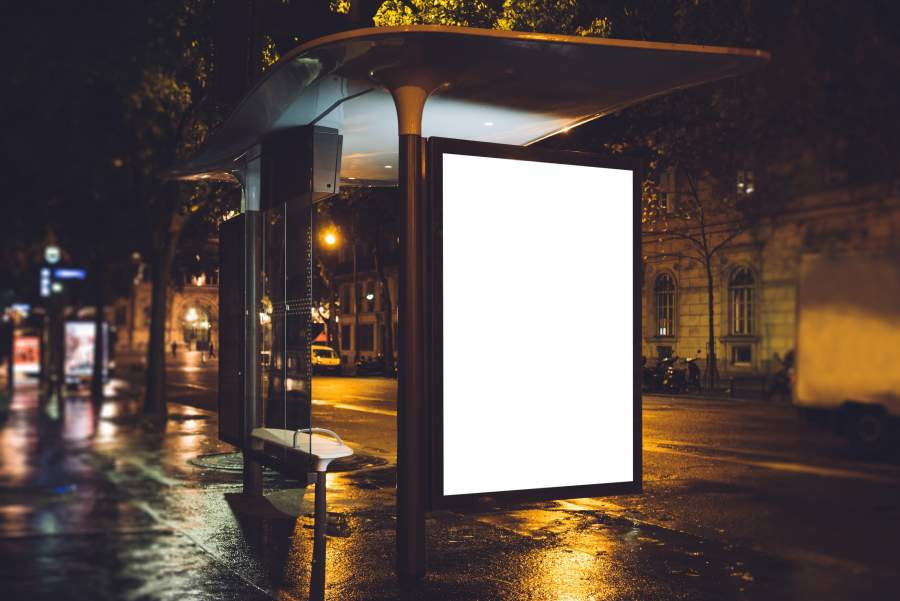 Eine leere Werbefläche für Außenwerbung an einer dunklen Bushaltestelle.