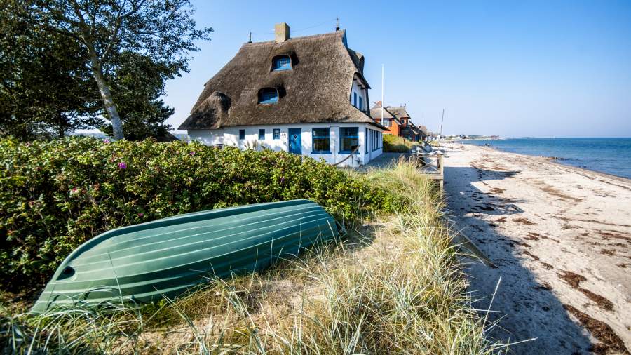 Ferienhaus und Boot direkt am Sandstrand an der Ostsee in Deutschland