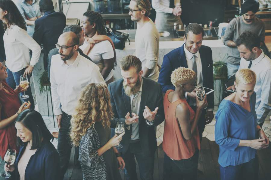 Diverse Personen in Business Casual Look in einem Foyer bei Business-Veranstaltung