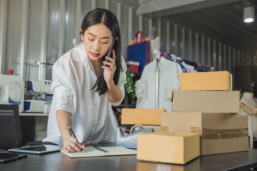 Frau packt Pakete in ihrem Laden e-commerce