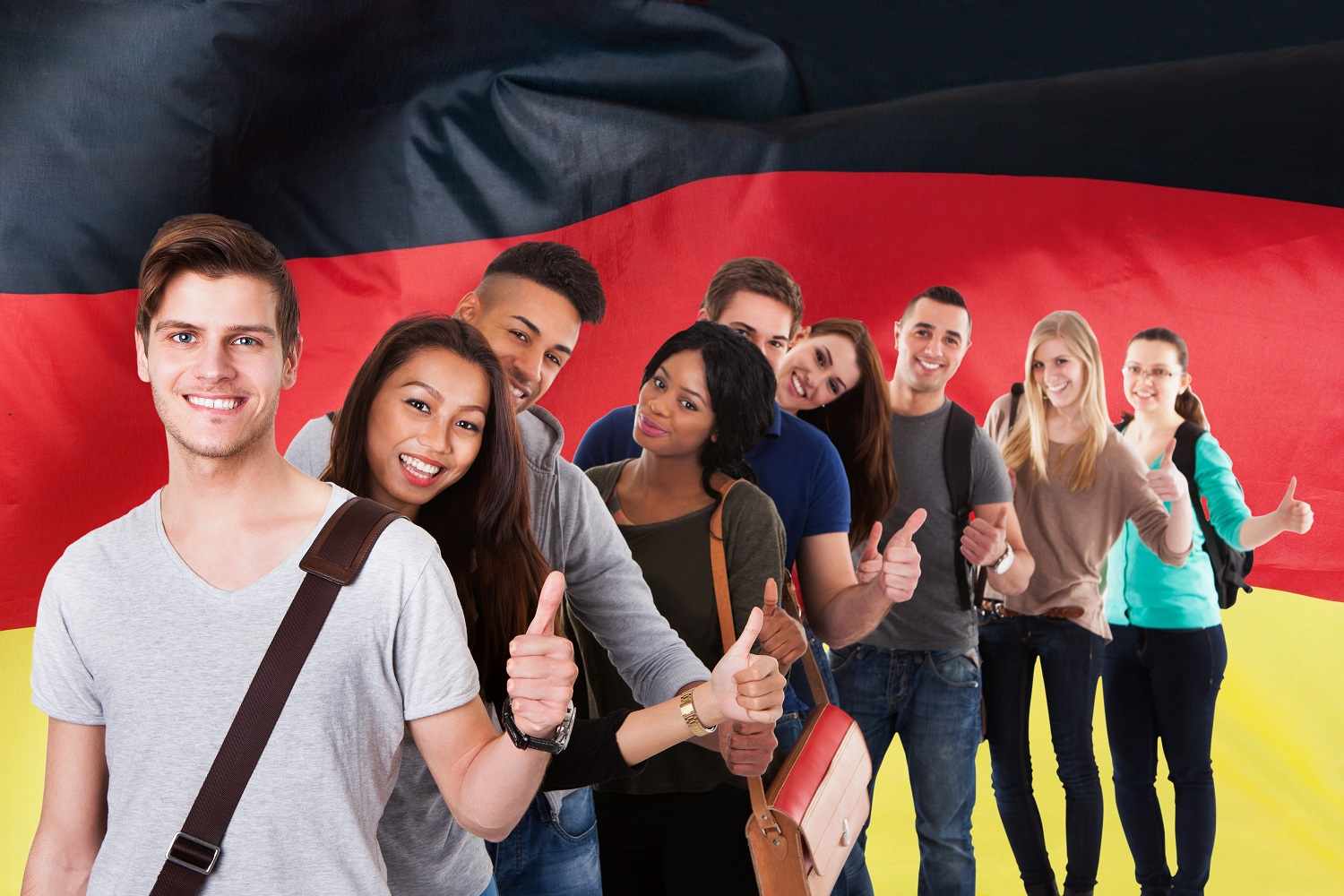 Junge Menschen verschiedener Herkunft stehen fröhlich vor Deutschlandflagge und wollen Deutsch lernen