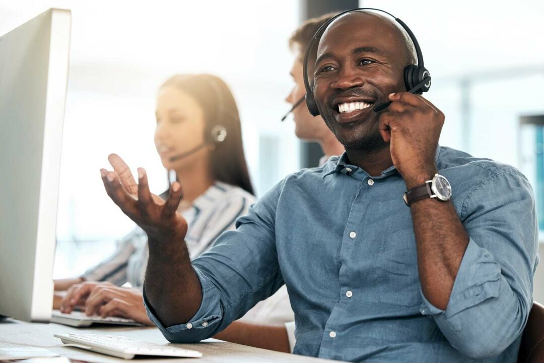 schwarzer mann nutzt lächelnd sip-telefonie für ein kundengespräch