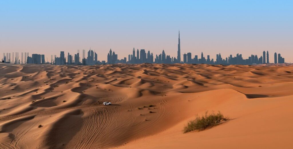 : wüstensafari mit dubais skyline im hintergrund